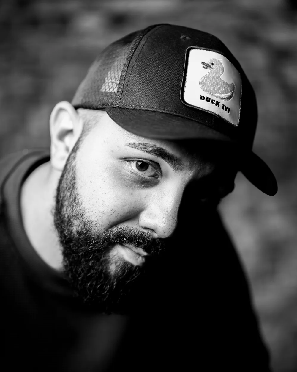 Primo piano in bianco e nero di un uomo con barba e cappello
